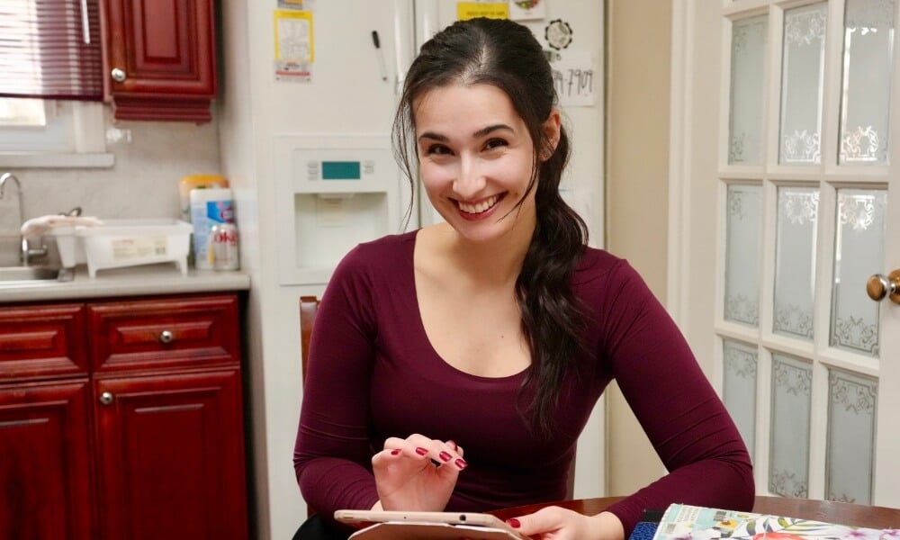 Photo of Diana Skakavac in her kitchen holding a tablet