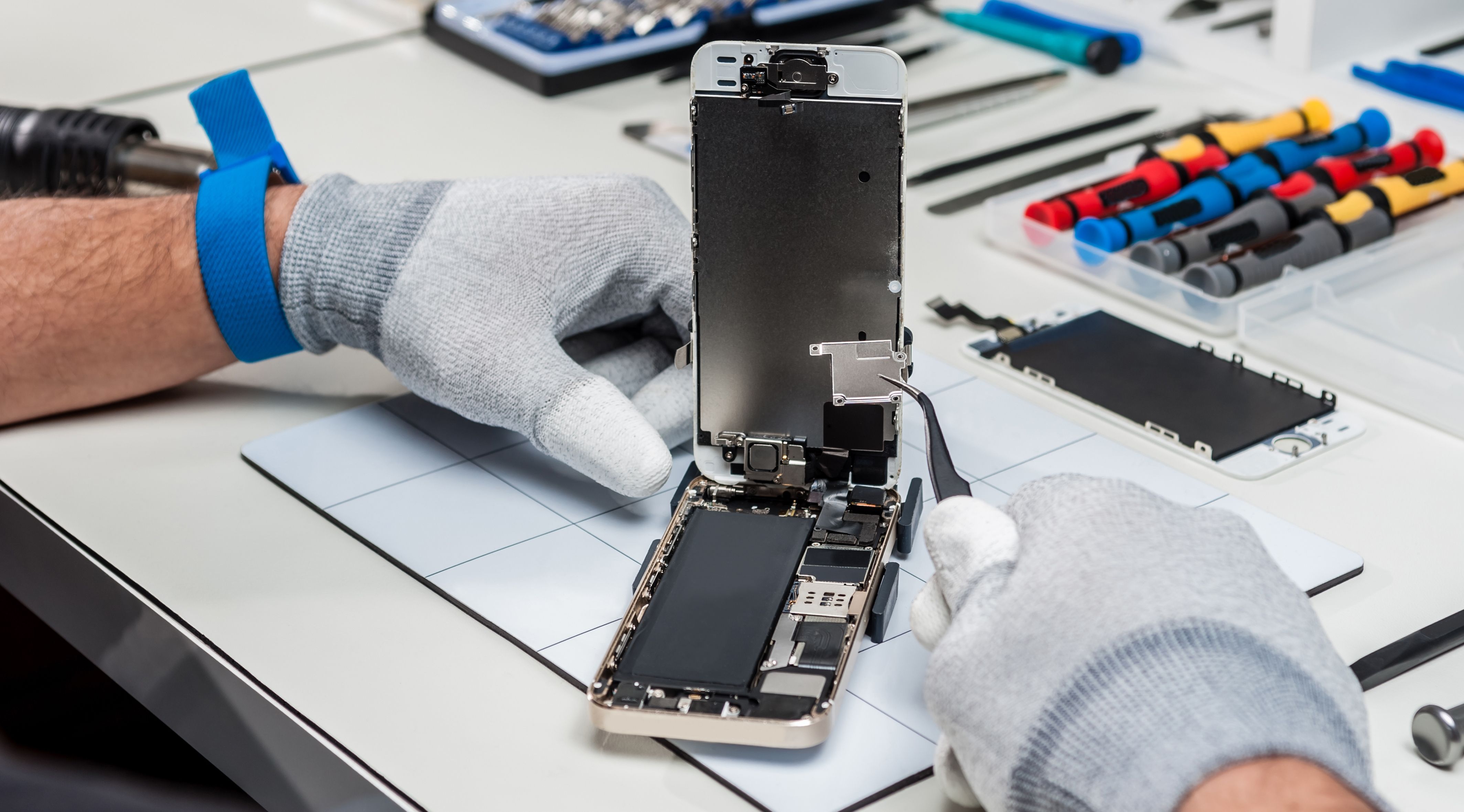 A smartphone being repaired by a technician