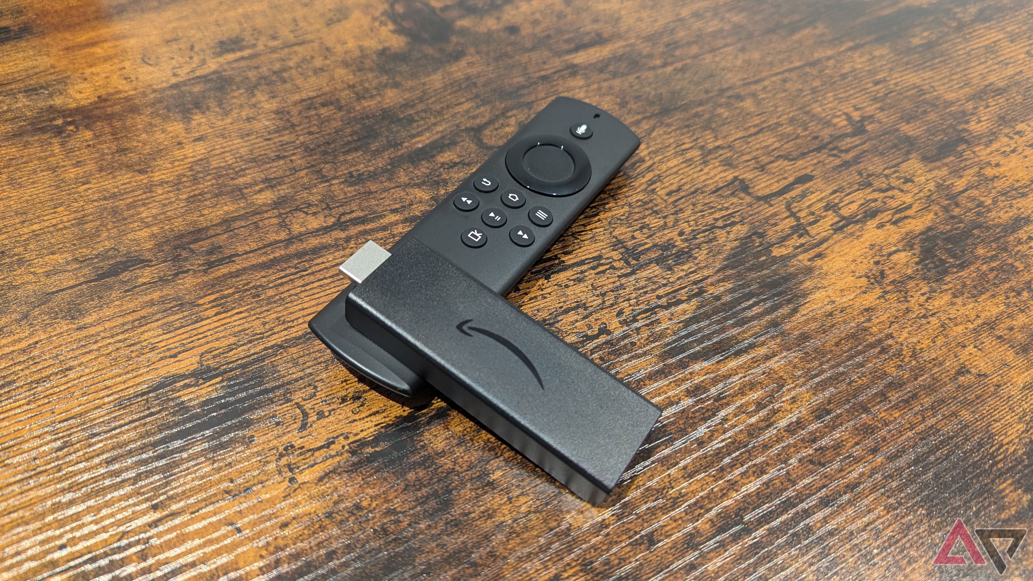 Amazon Fire TV Stick Lite lying on Alexa Voice Remote Lite on wood table