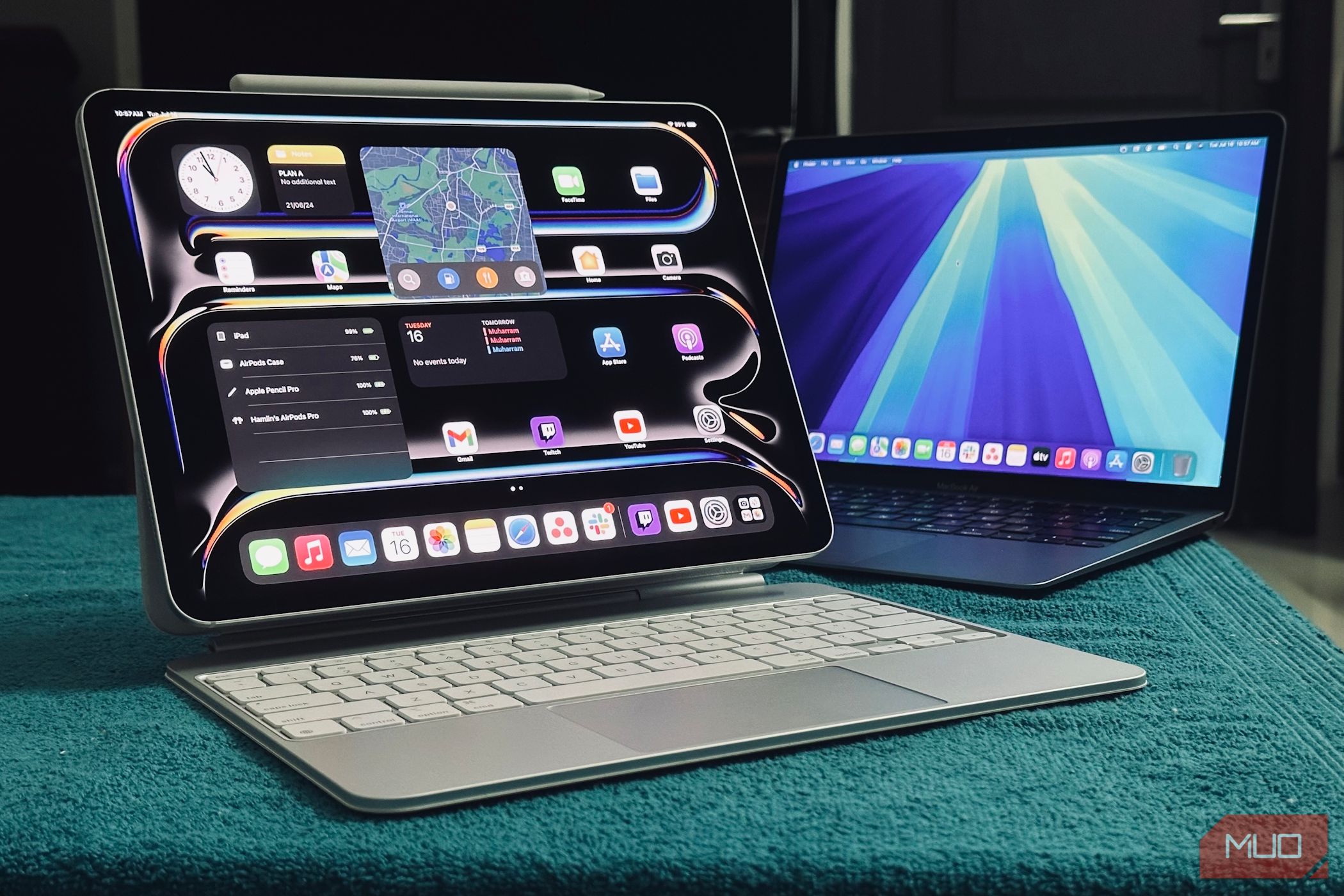 An iPad Pro attached to a Magic Keyboard next to a MacBook on a table