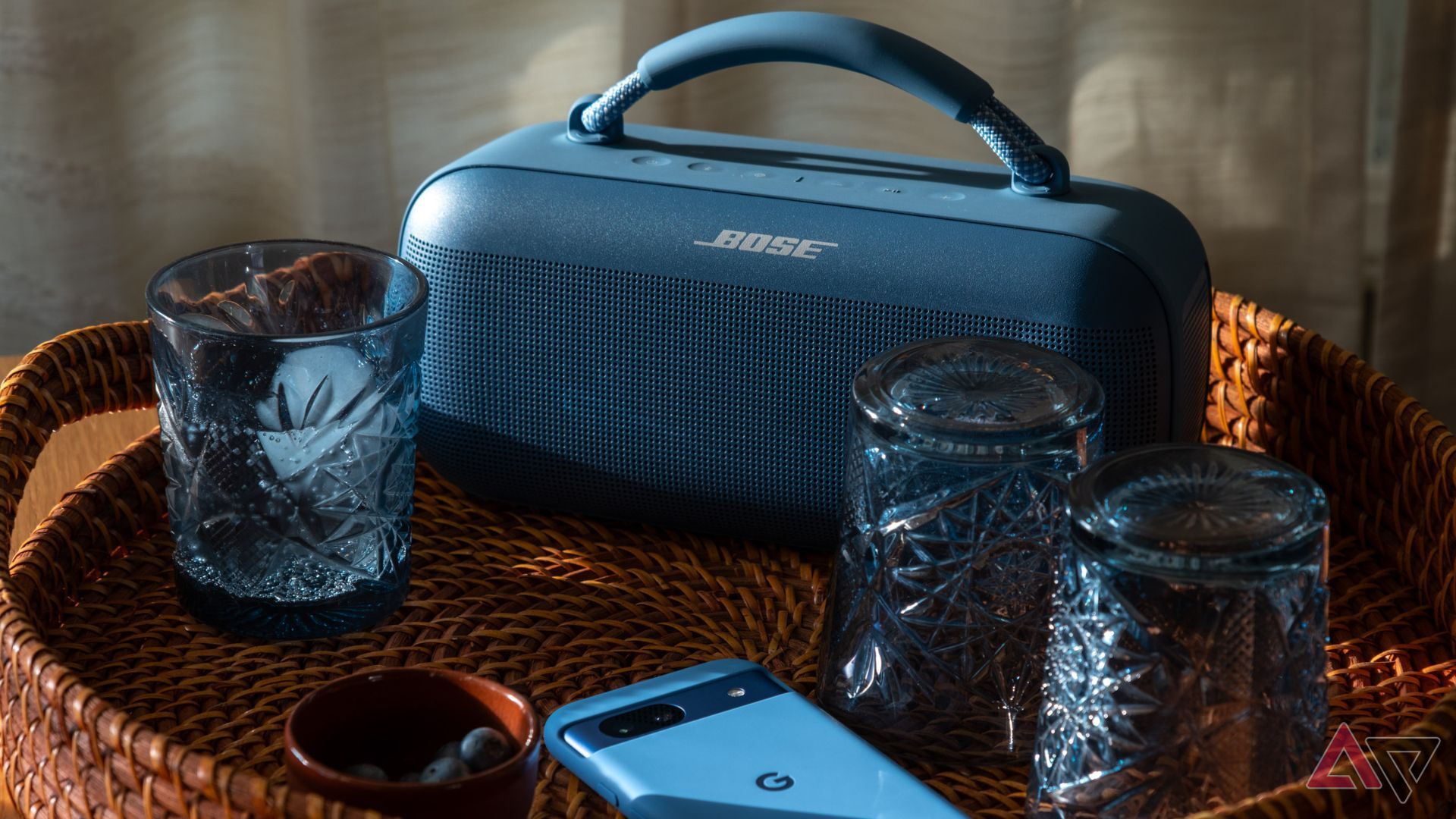 A blue Bose speaker on a tray with various other blue objects.