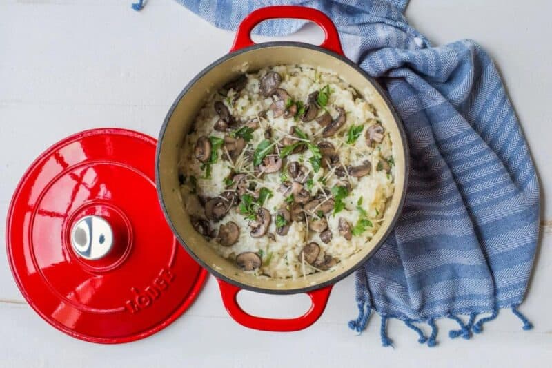 a red dutch oven filled with rice and mushrooms