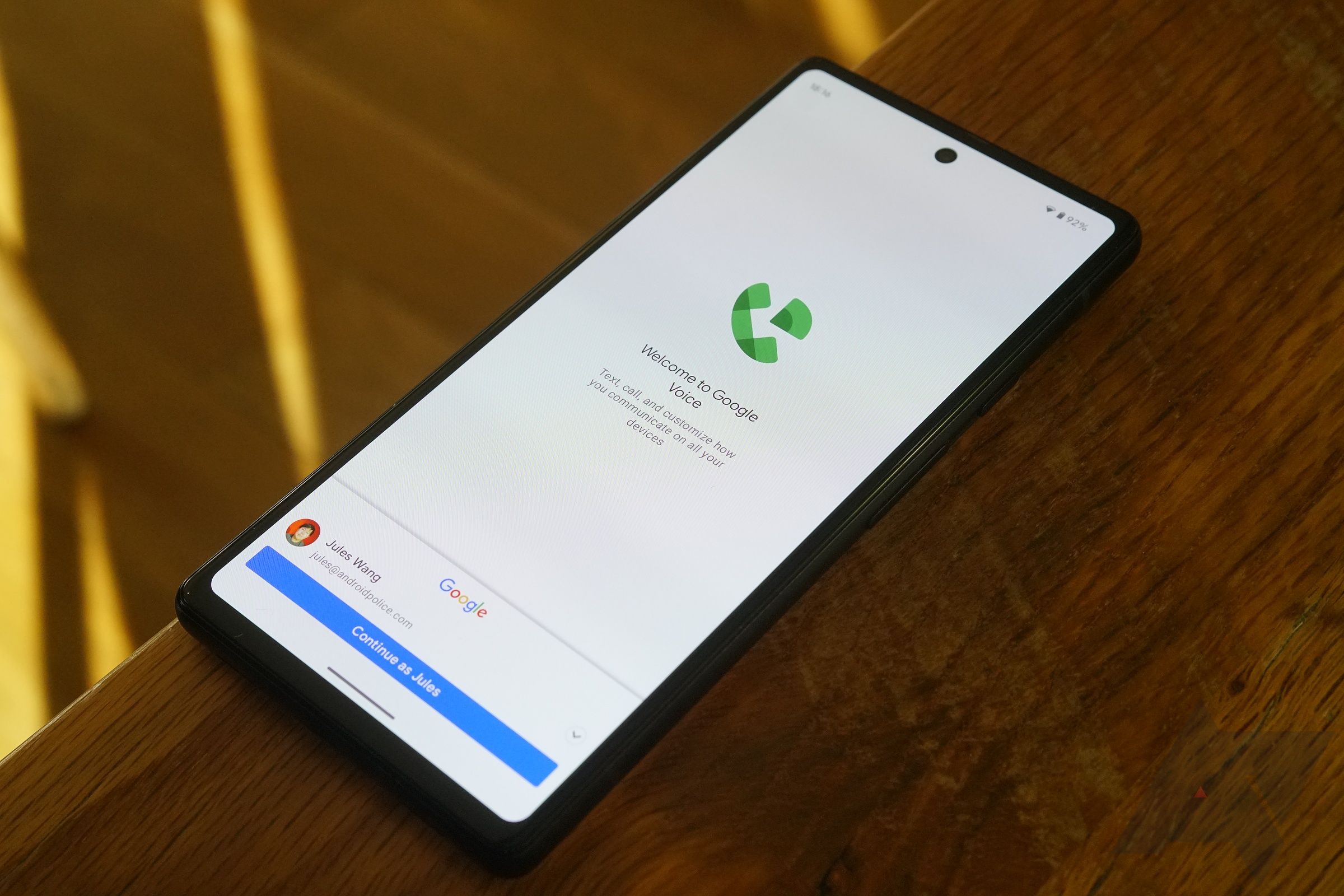 An Android phone on a wooden table with the Google Voice app open being set up for the first time