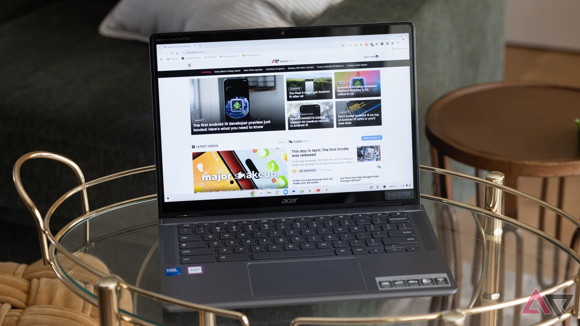 The Acer Chromebook Plus Spin 514 on a glass table in front of a green couch