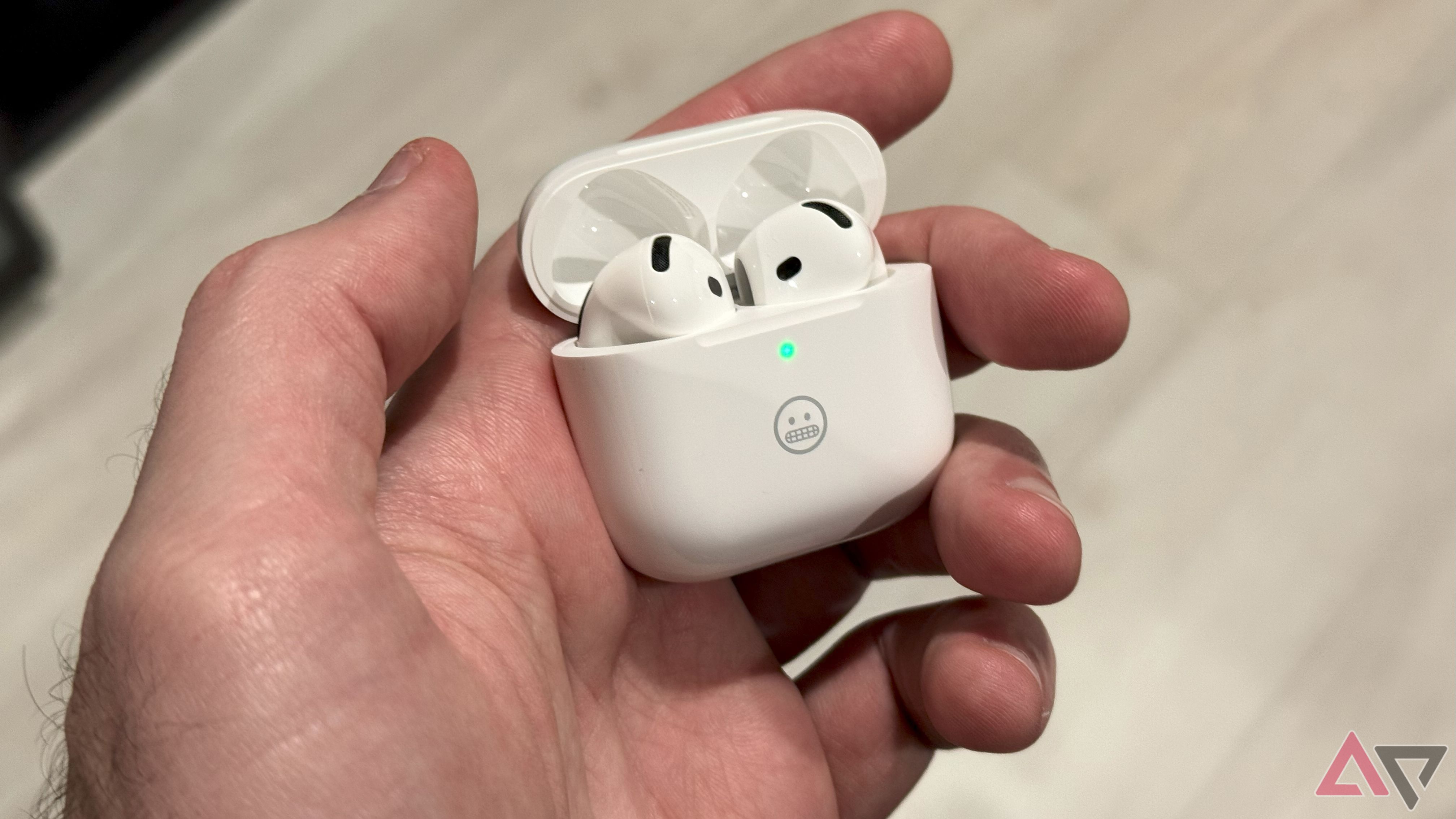 Holding the AirPods 4's charging case in hand