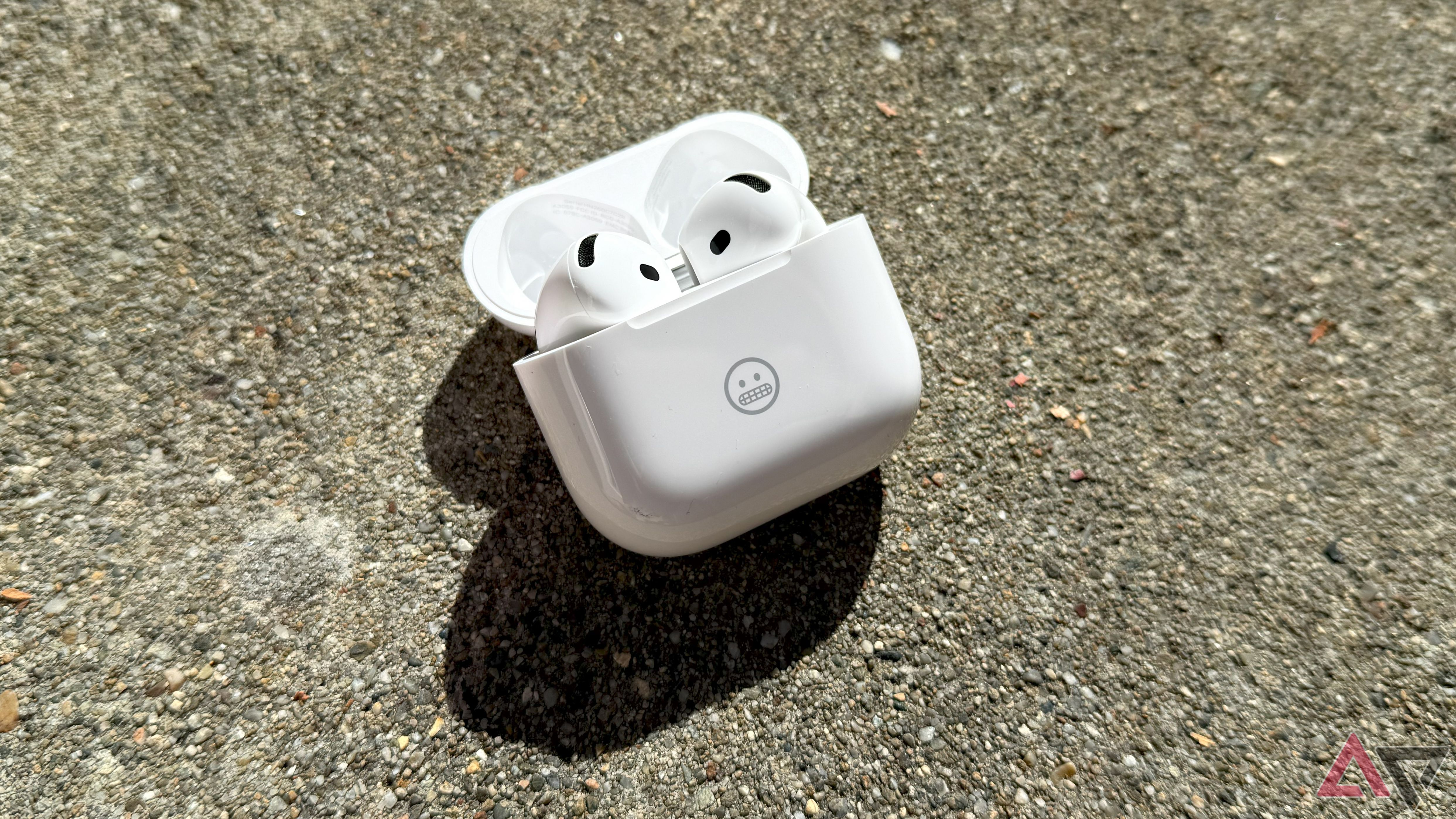 A top-down shot of the AirPods 4 in an open case on a textured surface