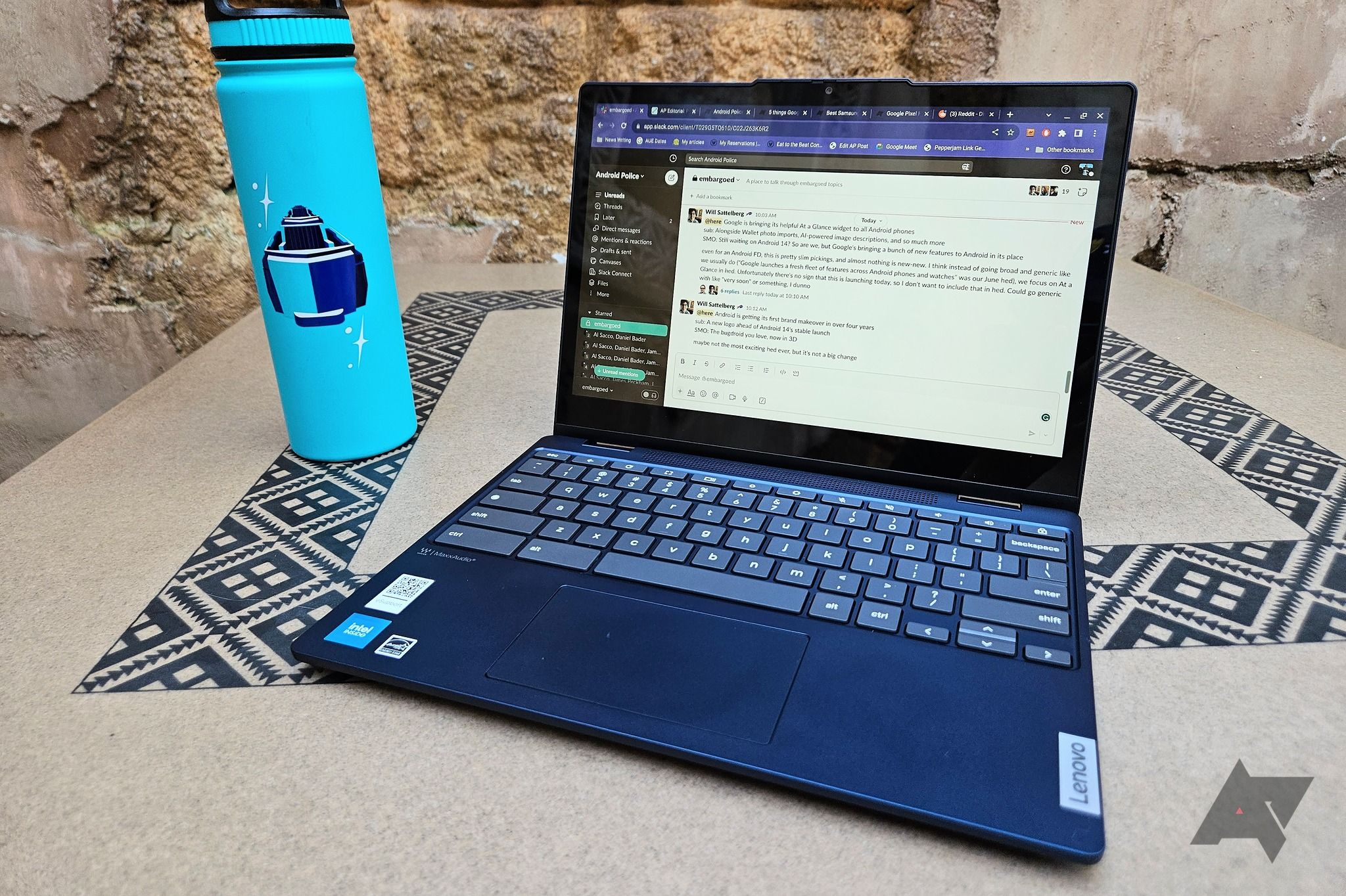 A Lenovo Flex 3i Chromebook (Gen 8) sitting on a table with a mosaic pattern next to a blue water bottle