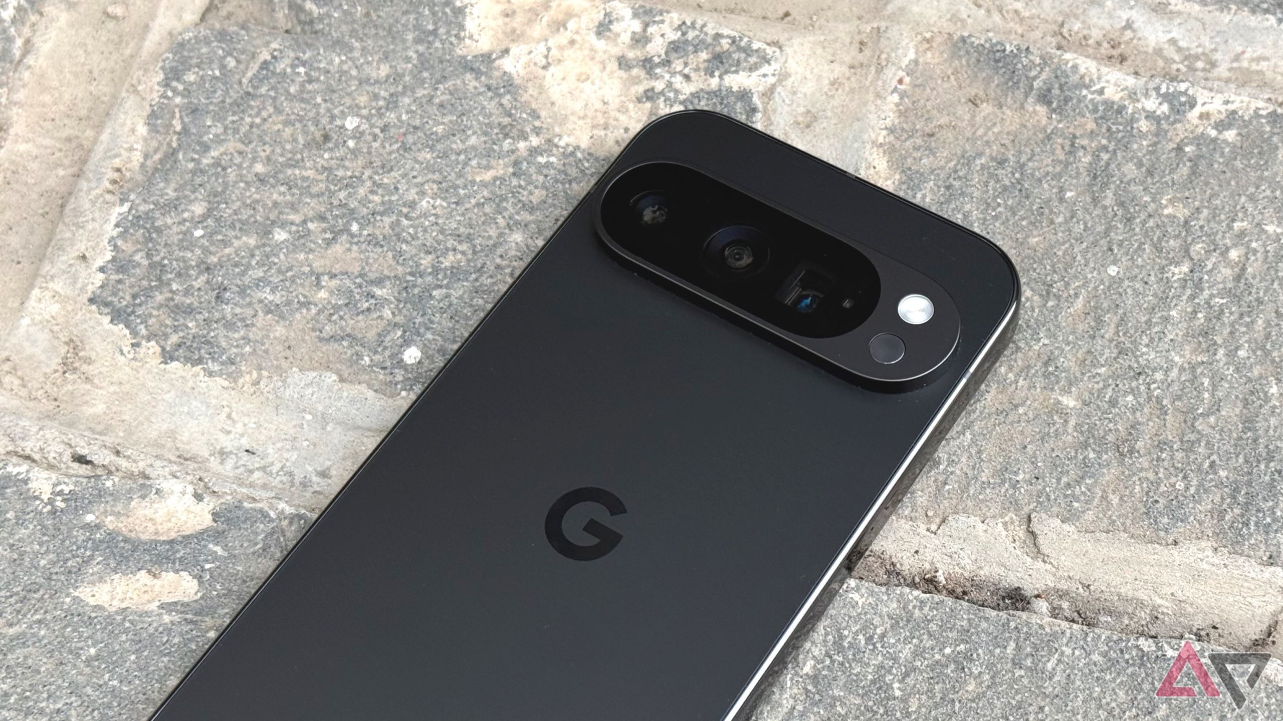 A Google Pixel 9 Pro camer phone with a stone background