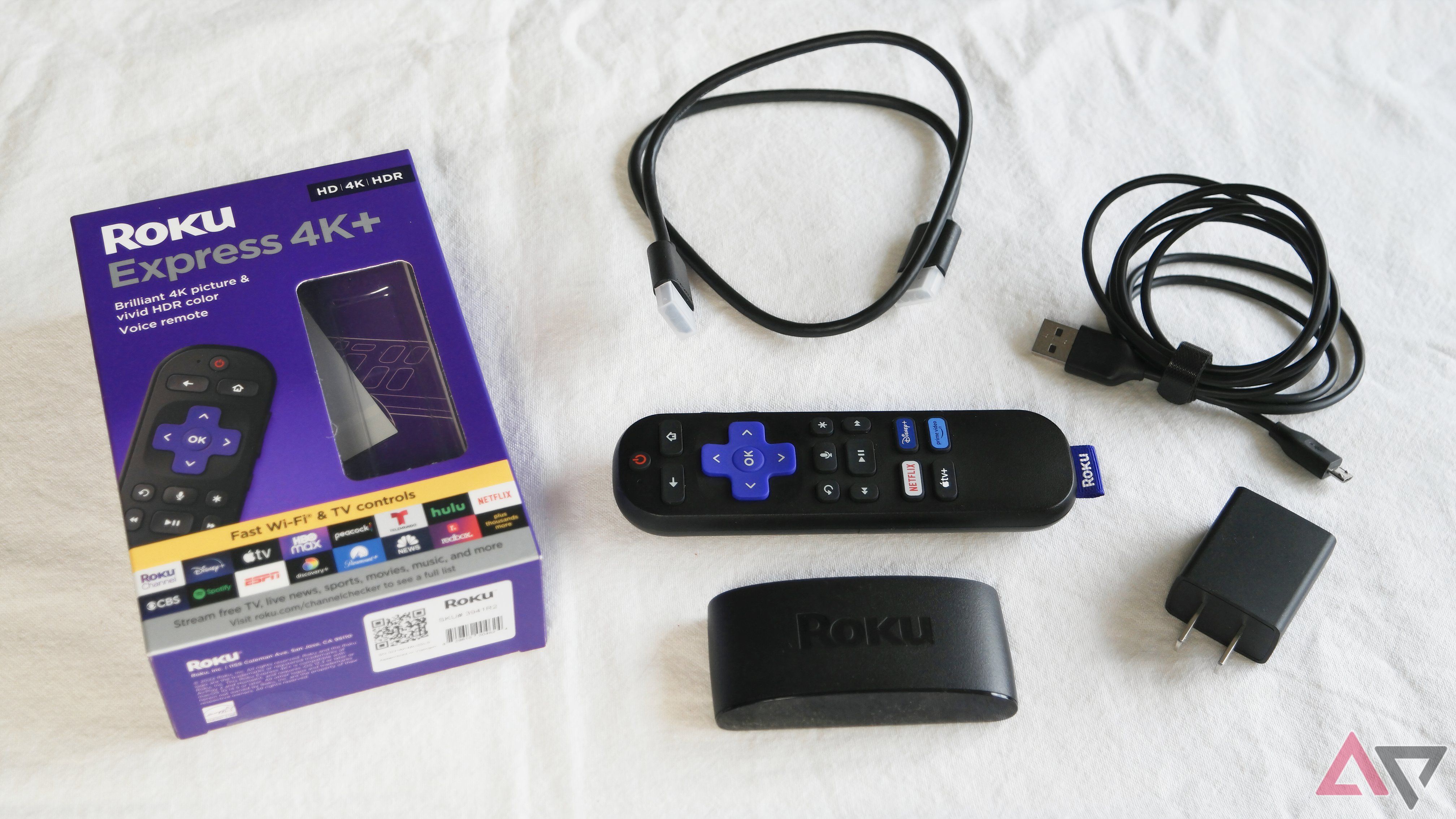 The Roku Express 4K+ unboxed, all of the components laid out on a table