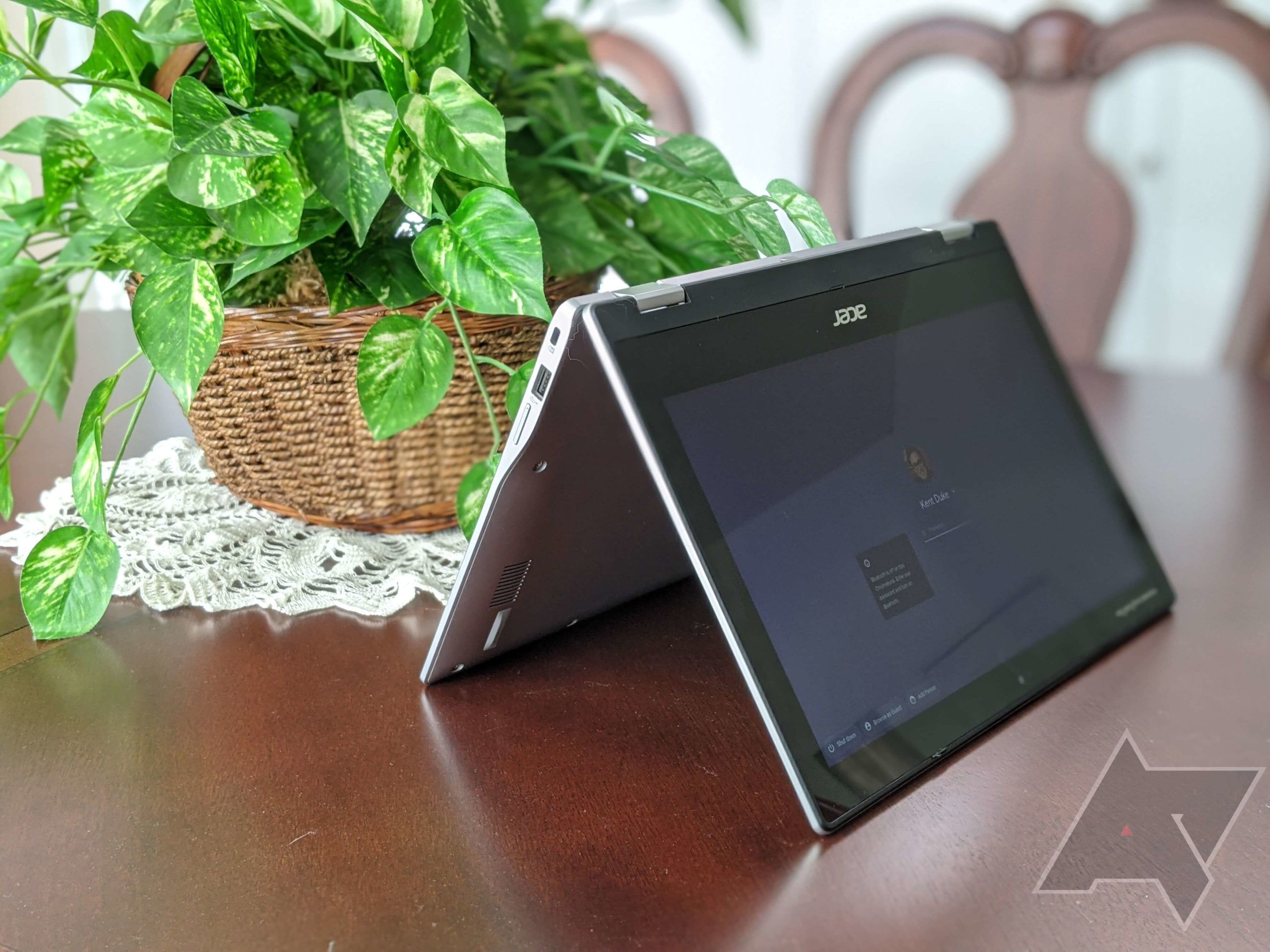 Acer Chromebook Spin 311, tented on a table near a plant