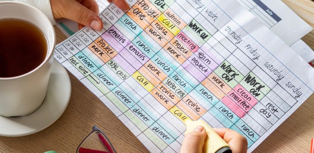 Woman holding a marker to a time blocked schedule