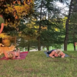 man trying to catch his dog around two girls doing yoga.png