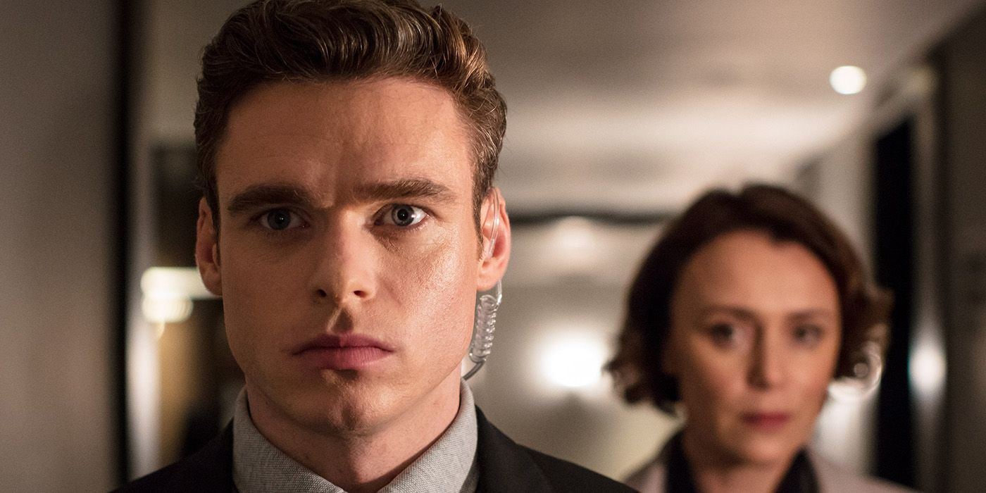 A close-uo of David looking worried, a woman behind him in a scene from Bodyguard.