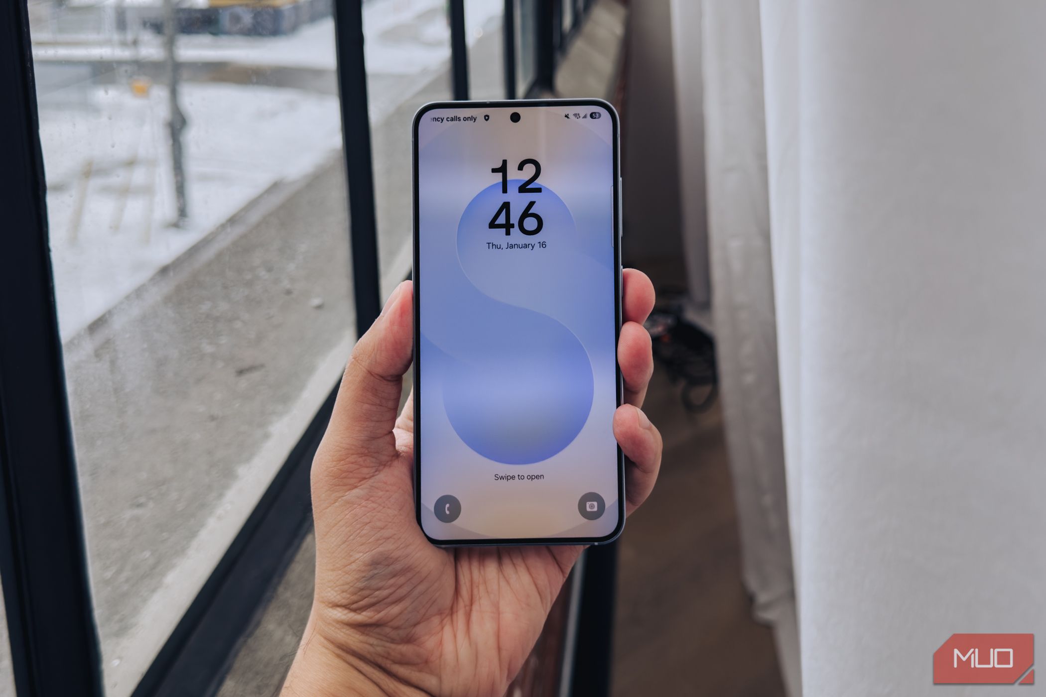 Samsung Galaxy S25 lockscreen against a window.