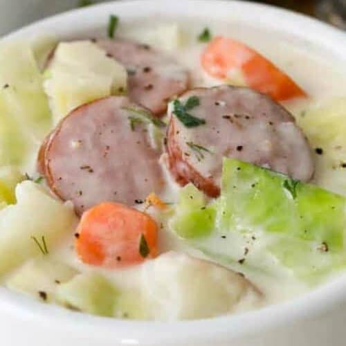 Cabbage and sausage soup in a bowl with a title